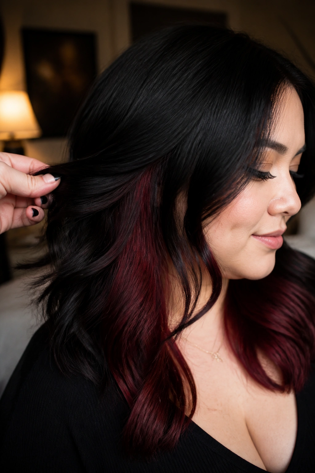 Close-up portrait of a real woman with merlot peekaboo panels under jet black hair
