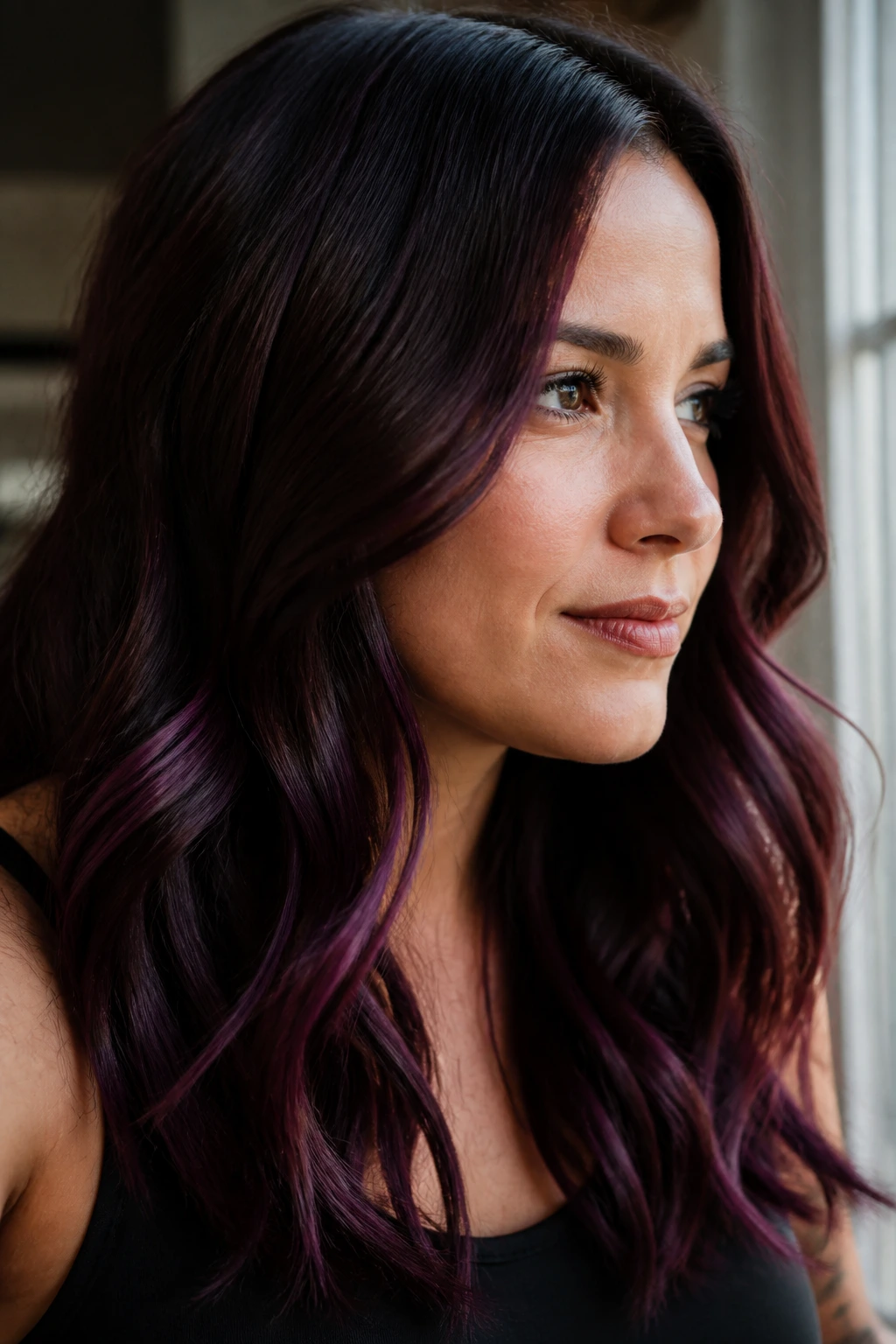 Close-up of merlot purple highlights on dark brown hair in natural window light