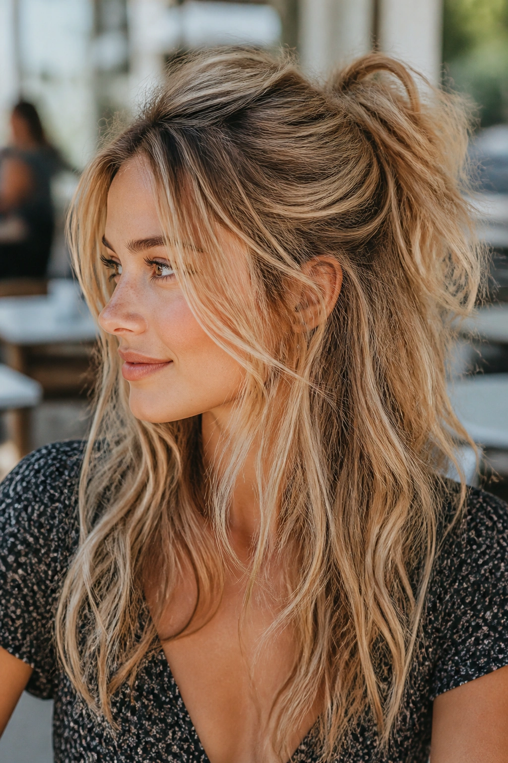 Real woman with messy undone half-up ponytail showing textured crown and loose pieces
