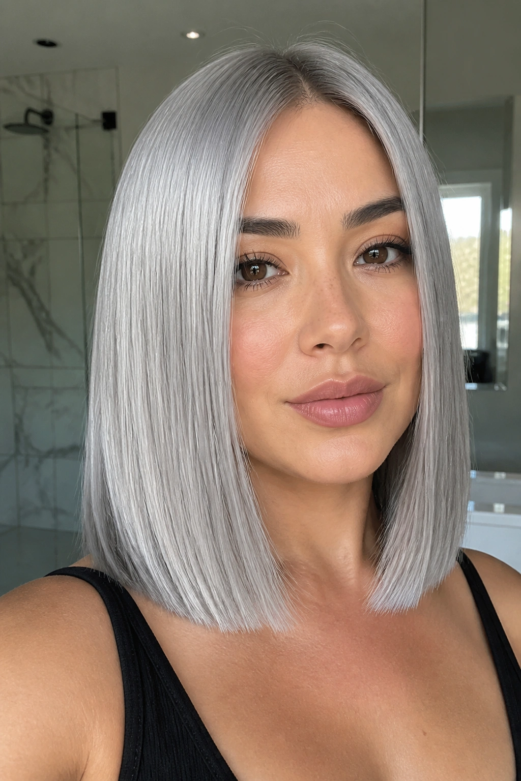 Close-up of a real woman with metallic silver sleek straight hair, collarbone length and high shine