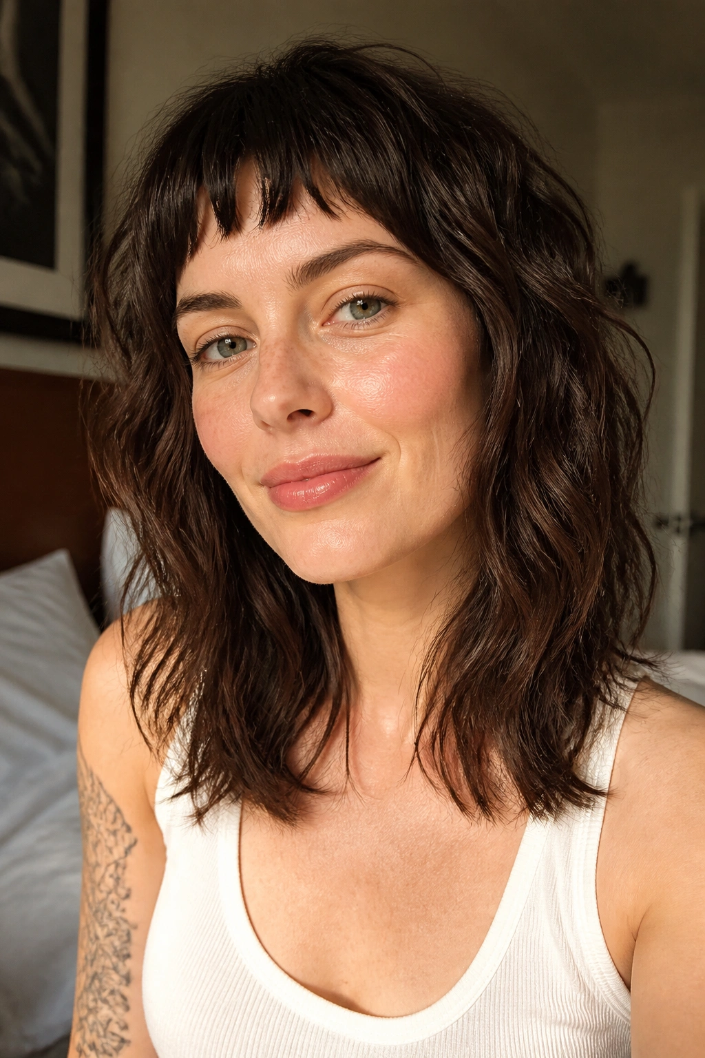 Close-up portrait of a real woman with micro bangs and soft waves in a shag