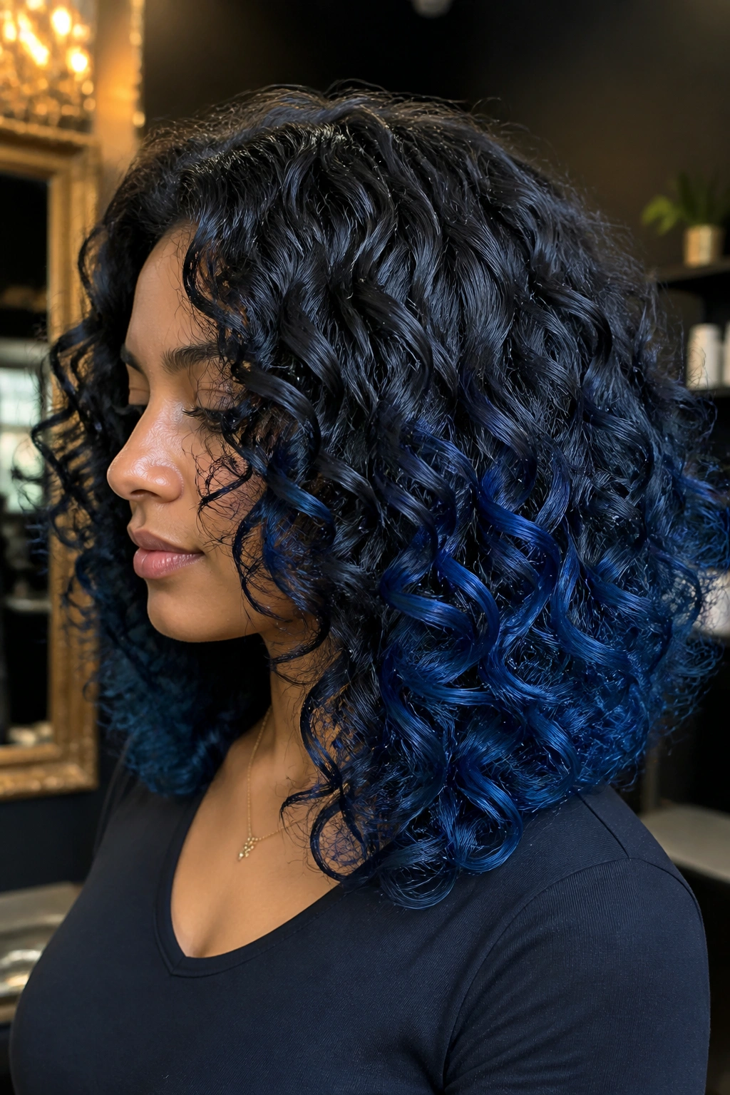 Close-up of a real person with curly hair showing deep midnight blue fade