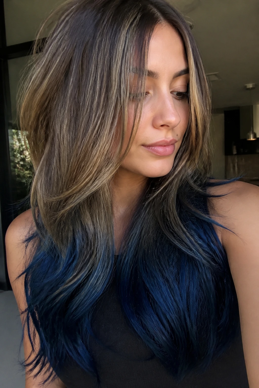 Long layered hair with midnight blue dip-dyed ends on a real person