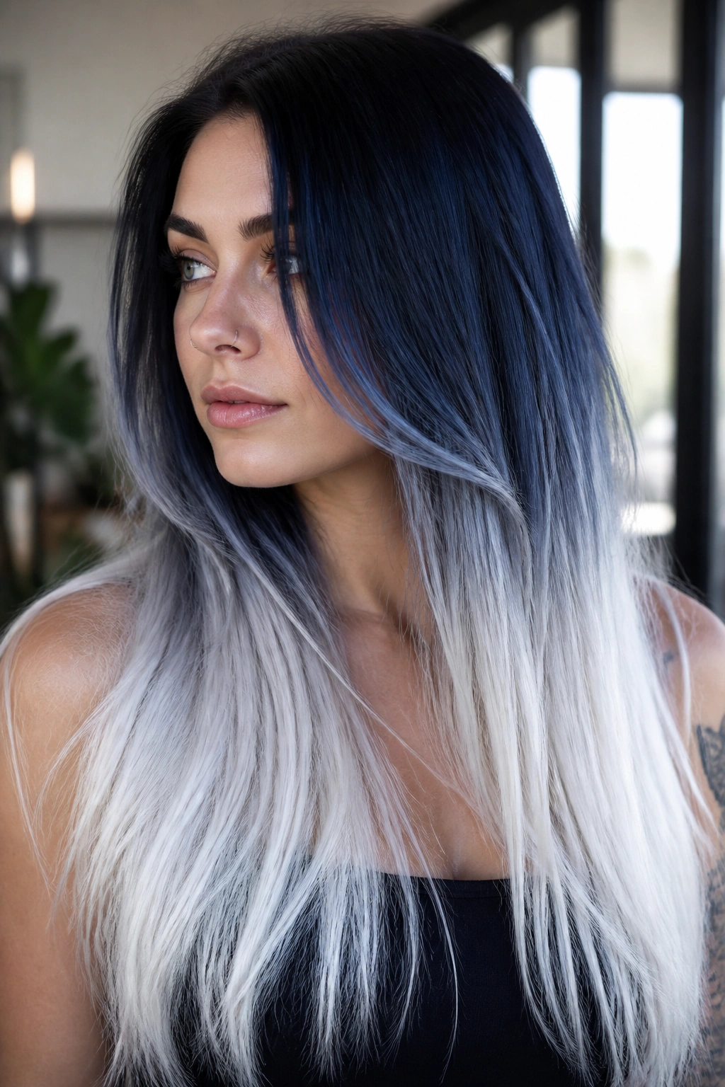 Close-up of a real woman with midnight blue roots fading to white tips on long hair