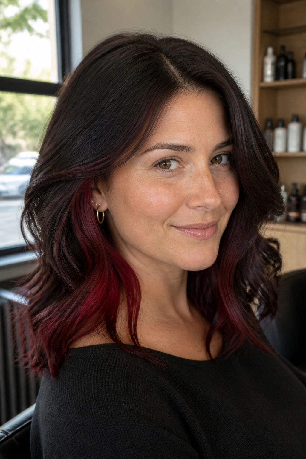Portrait of a real woman with midnight burgundy peekaboo panels tucked under a darker crown.