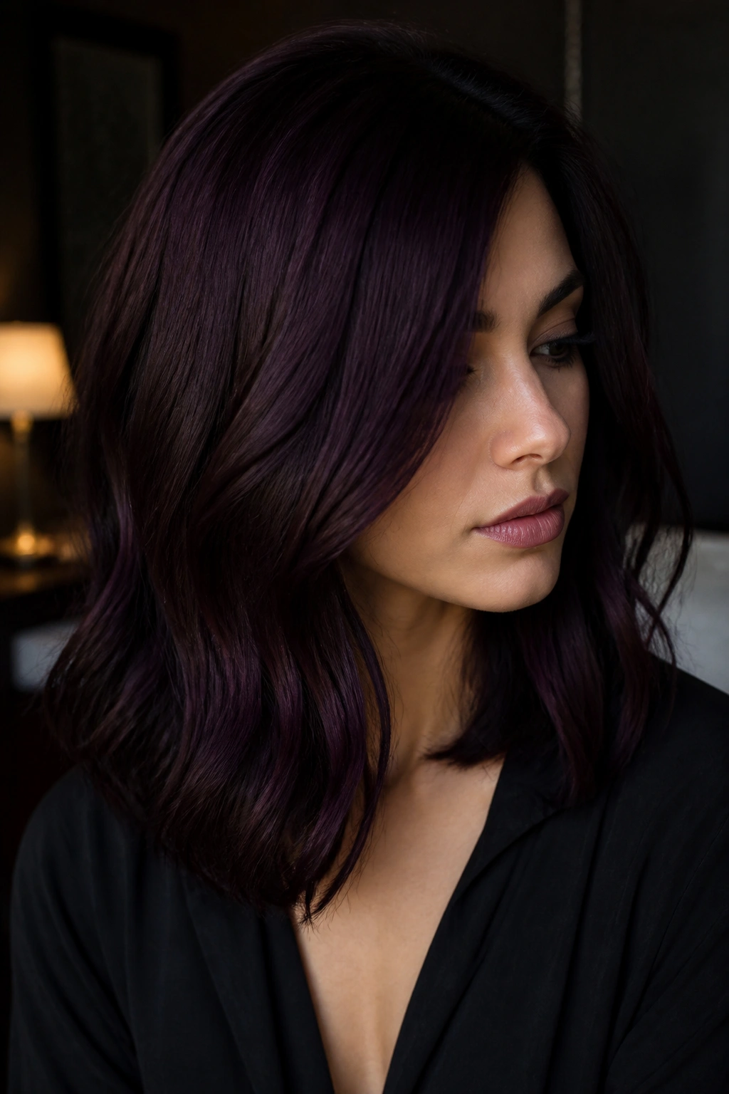 Real woman with Midnight Plum hair in moody lighting