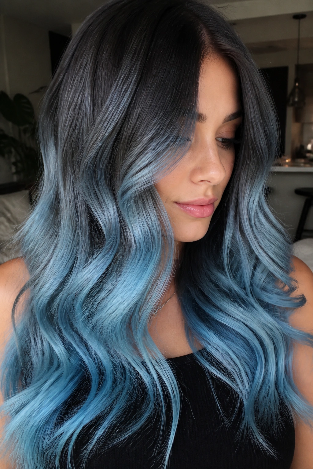 Close-up of a real person with dark root melt transitioning to blue ends.
