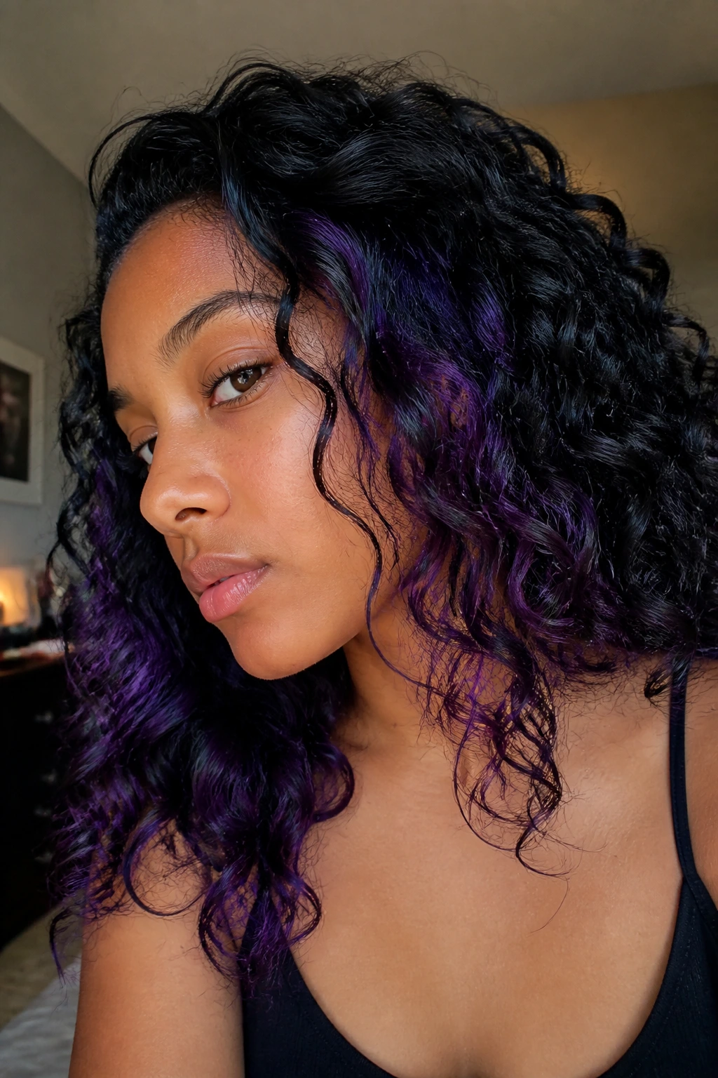 Close-up of a real person with midnight violet peekaboo panels under black hair