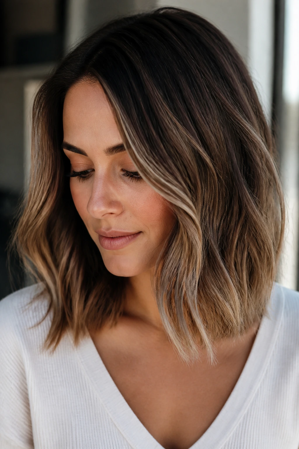 Close-up of mocha balayage on a collarbone-length lob on a real person