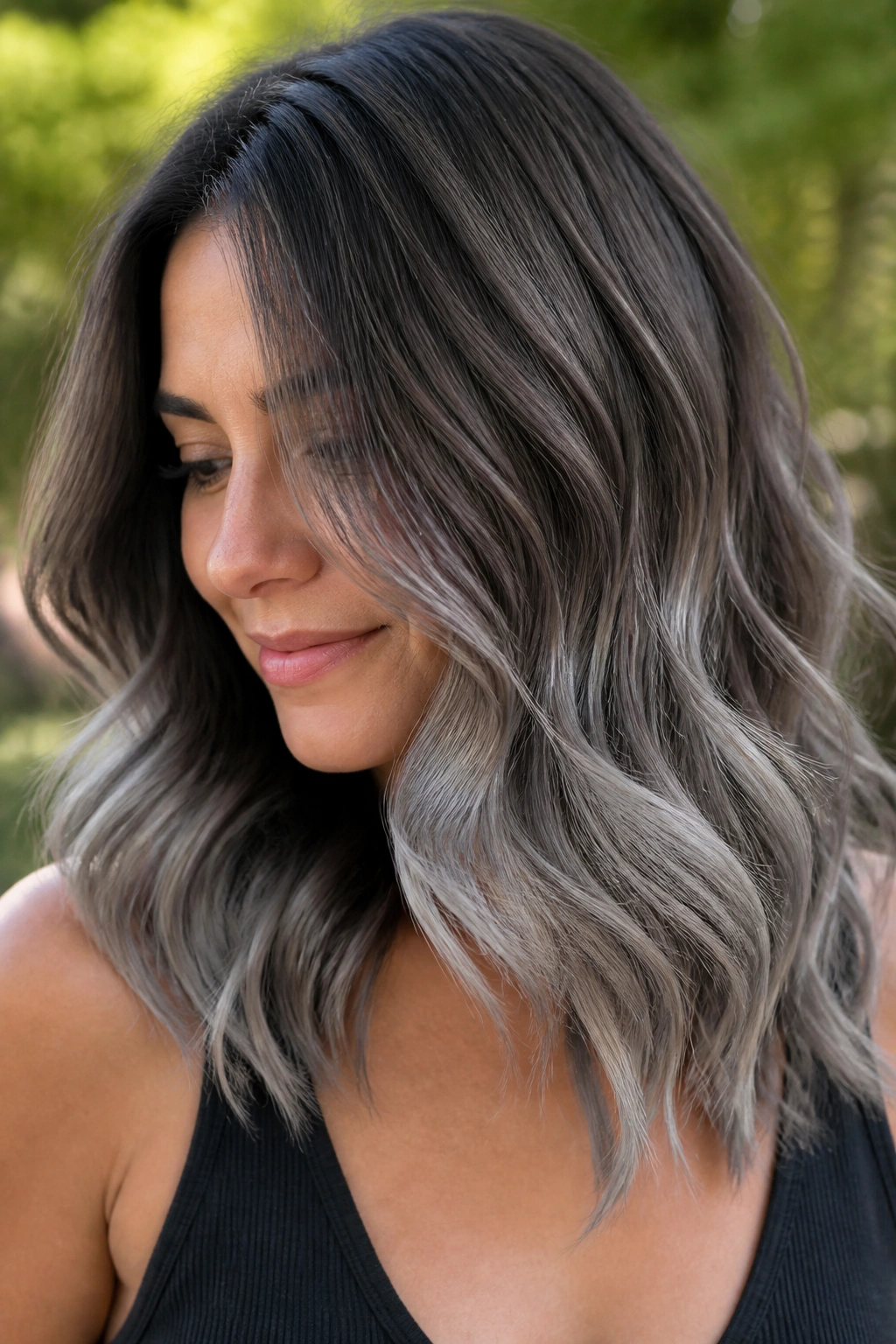 Close-up of a woman with smoky mocha balayage and silver ends on wavy hair