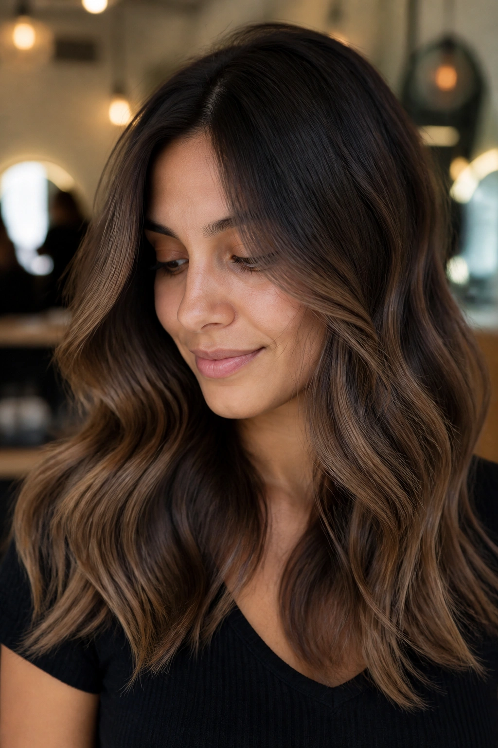 Close-up portrait of a real woman with deep brown base and mocha balayage highlights