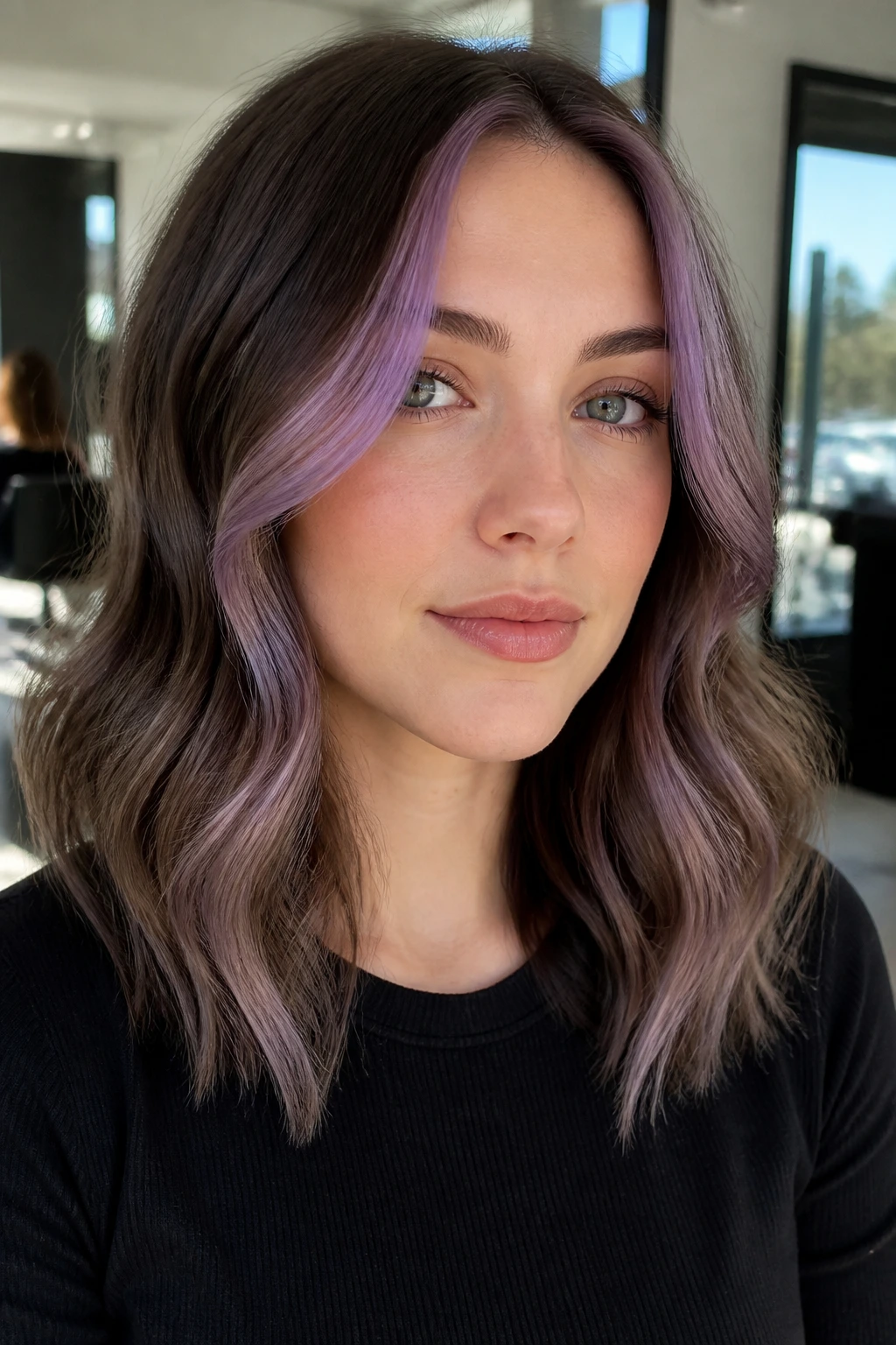Close-up portrait of a real person with face-framing lilac money pieces at the front hairline