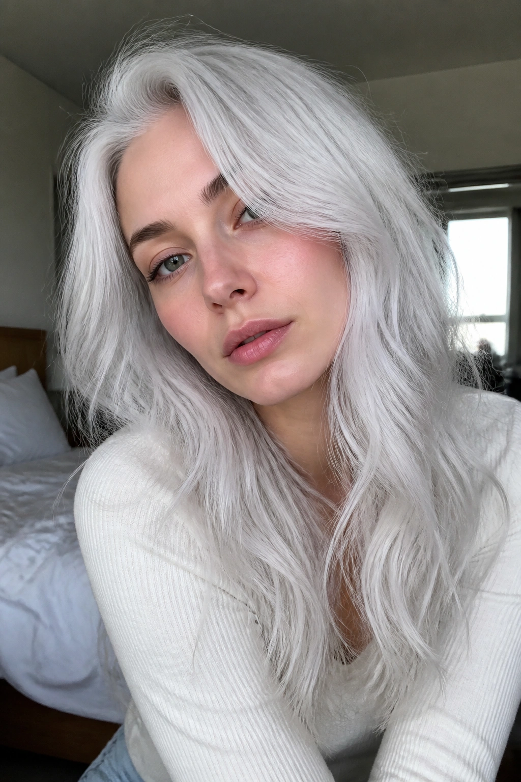 Close-up portrait of a real person with moonstone white hair in soft window light