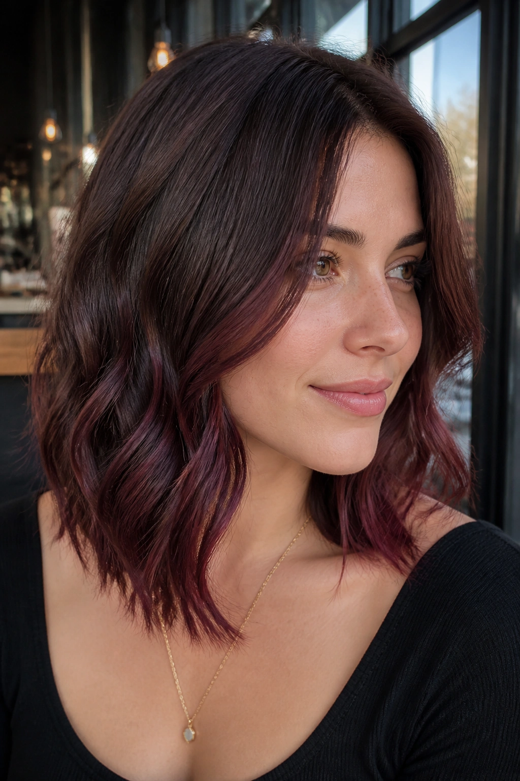 Portrait of a real woman with mulberry balayage lifting around the jawline.