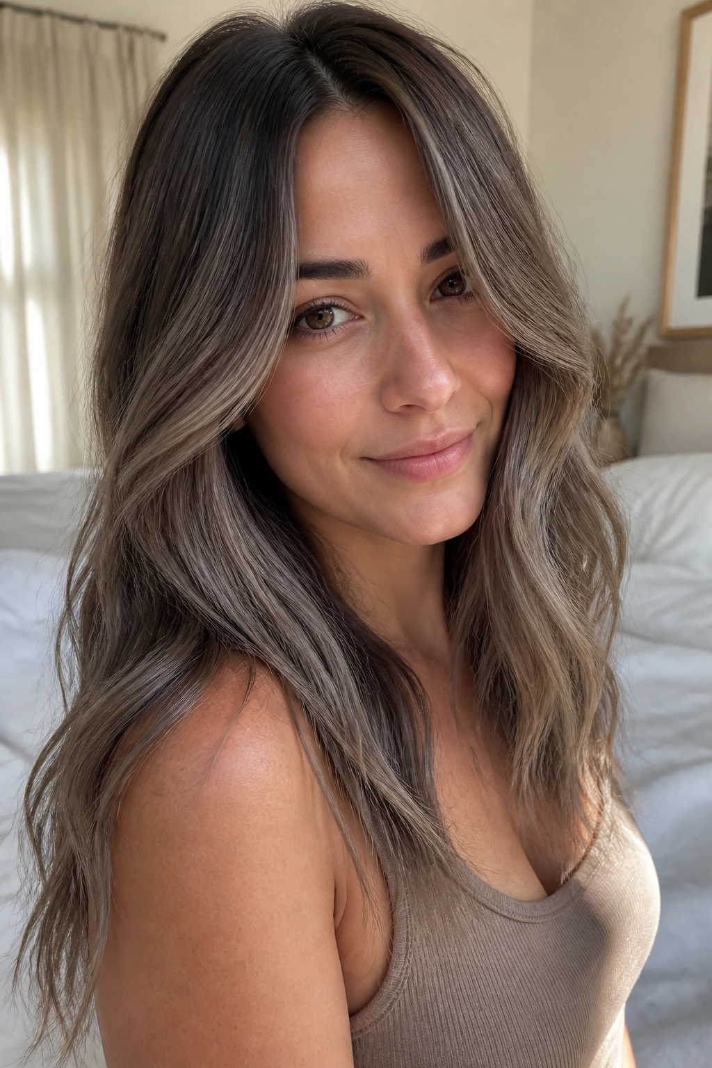 Close-up portrait of a real woman with mushroom brown balayage in cool taupe tones.