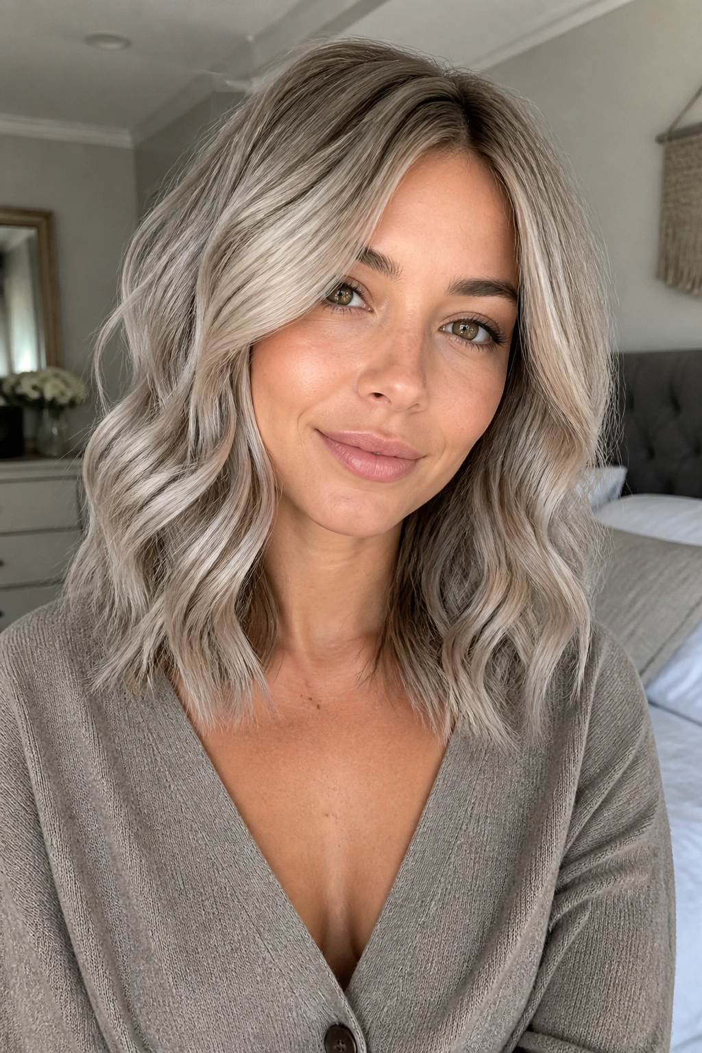 Shoulder-length mushroom silver blonde hair with subtle darker roots on a real person.