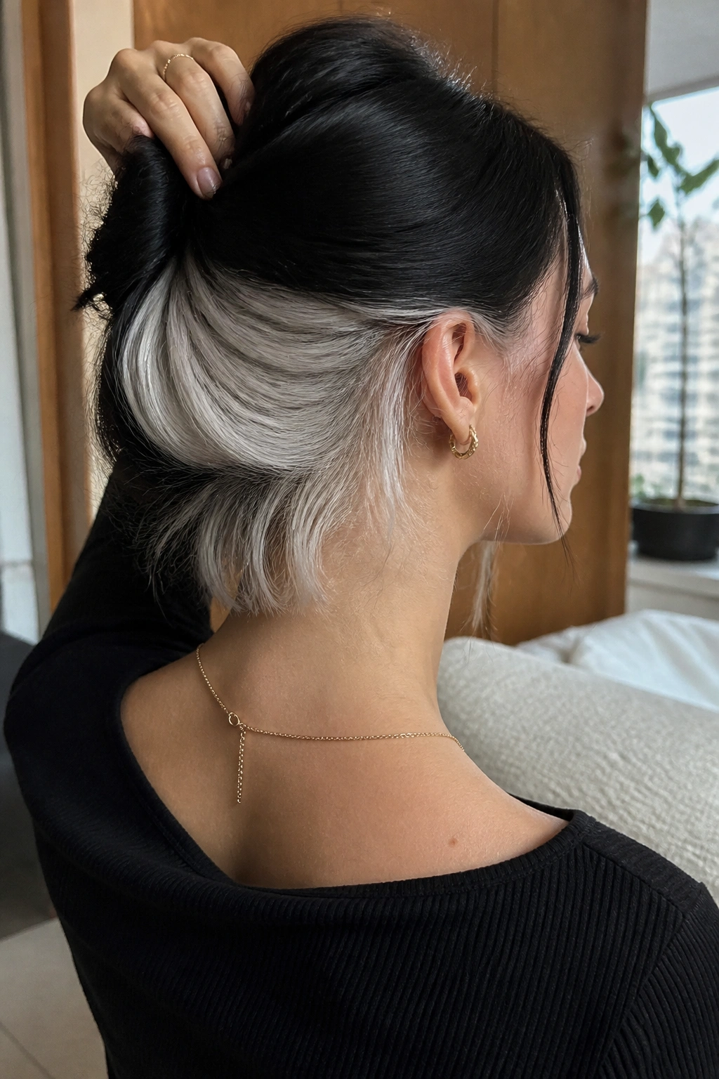 Back/side portrait showing white panels at the nape beneath black top layers.