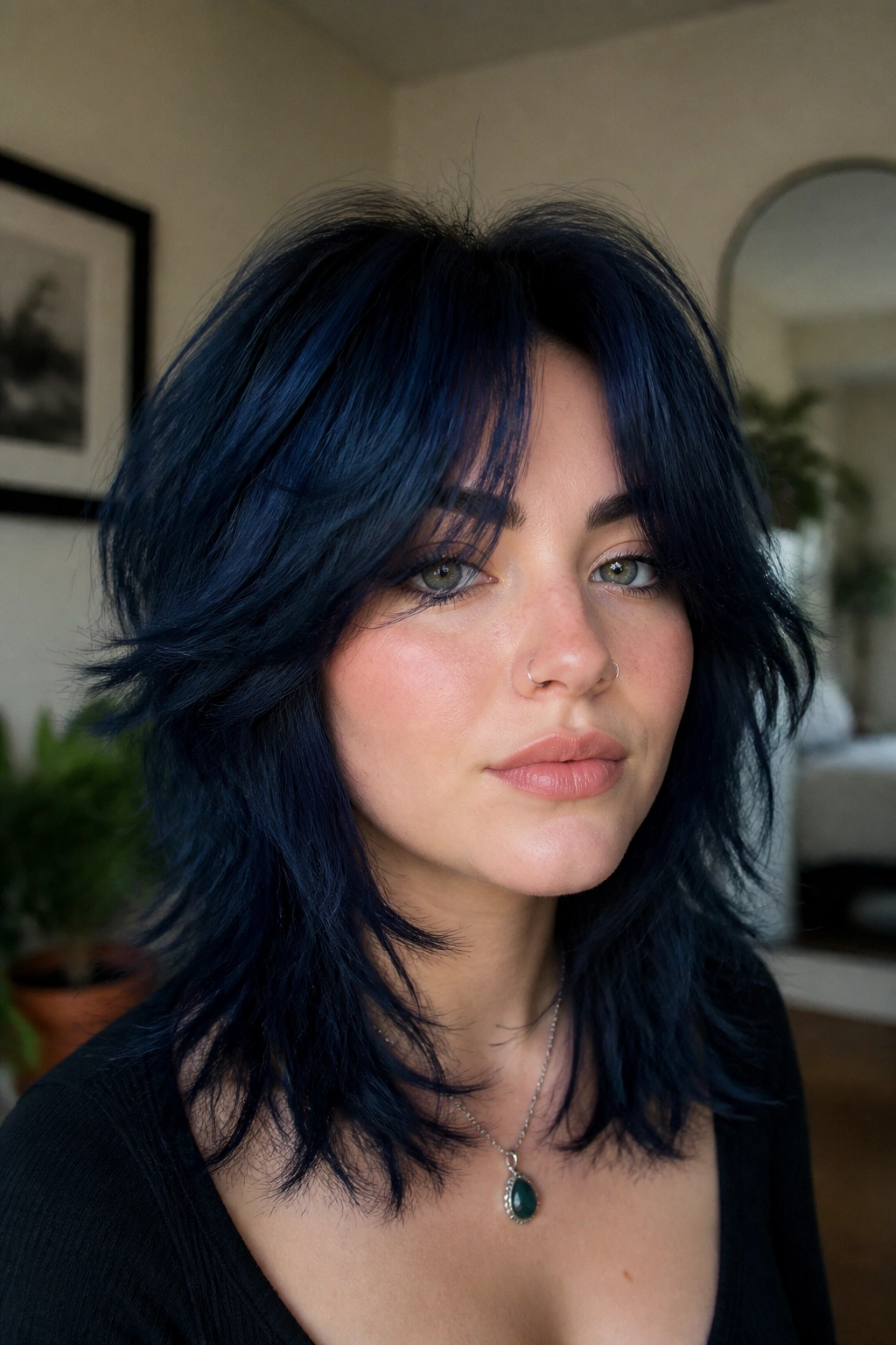 Close-up of a real woman with navy shag and curtain bangs.