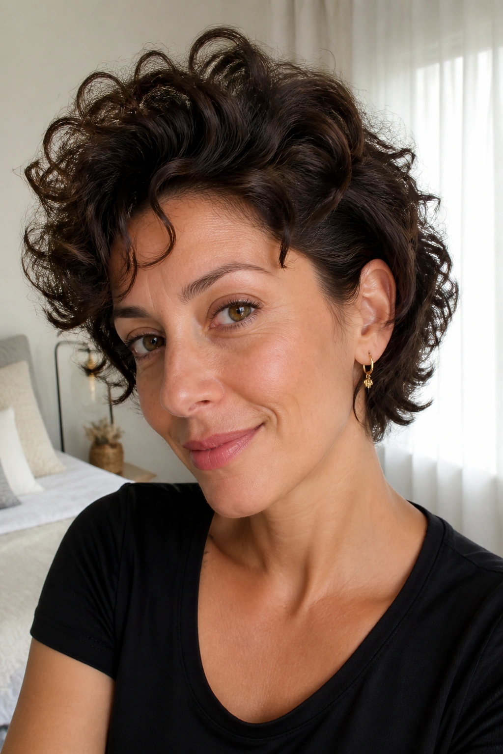 Close-up of a real woman with neck-length layered cut and crown volume in a sunlit bedroom