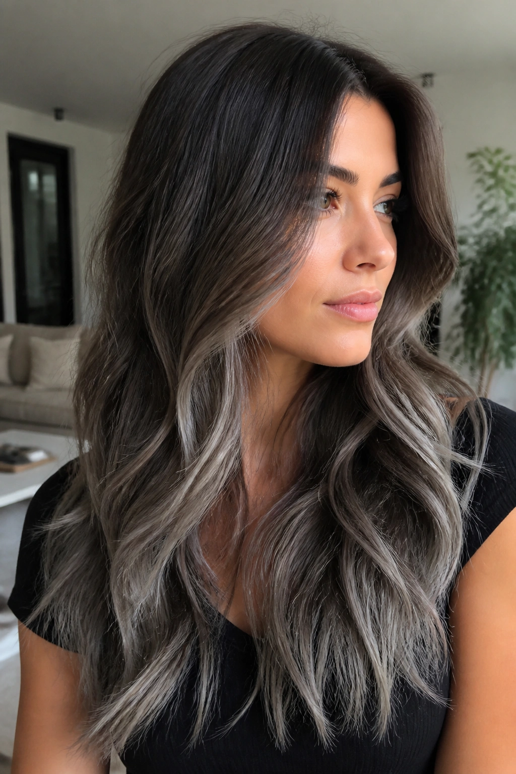 Real woman with neutral brunette to smoky silver ombre on long hair.