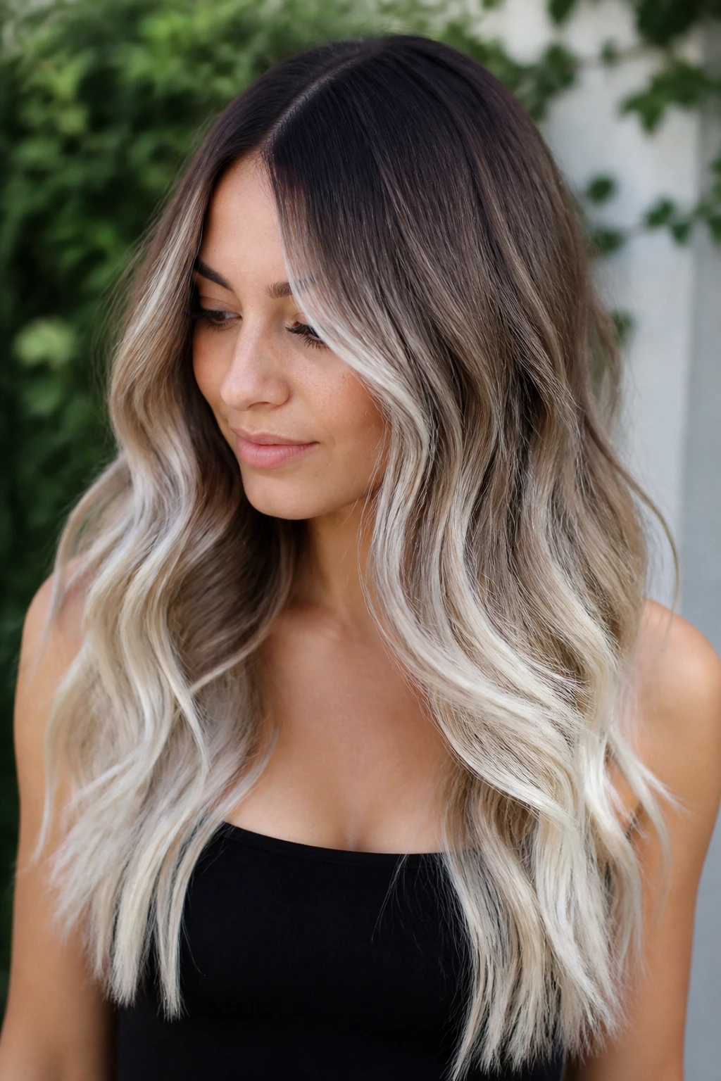 Portrait of a real woman with brown-to-ice ombré balayage and icy platinum ends.