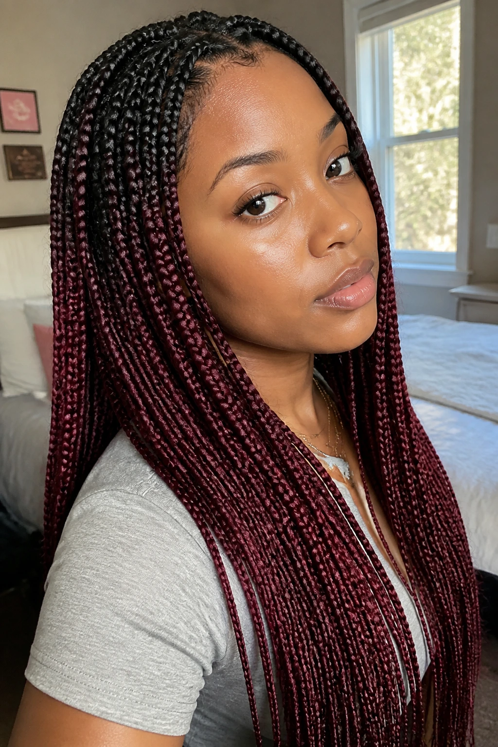 Close-up portrait of a real woman with ombre burgundy box braids and dark roots