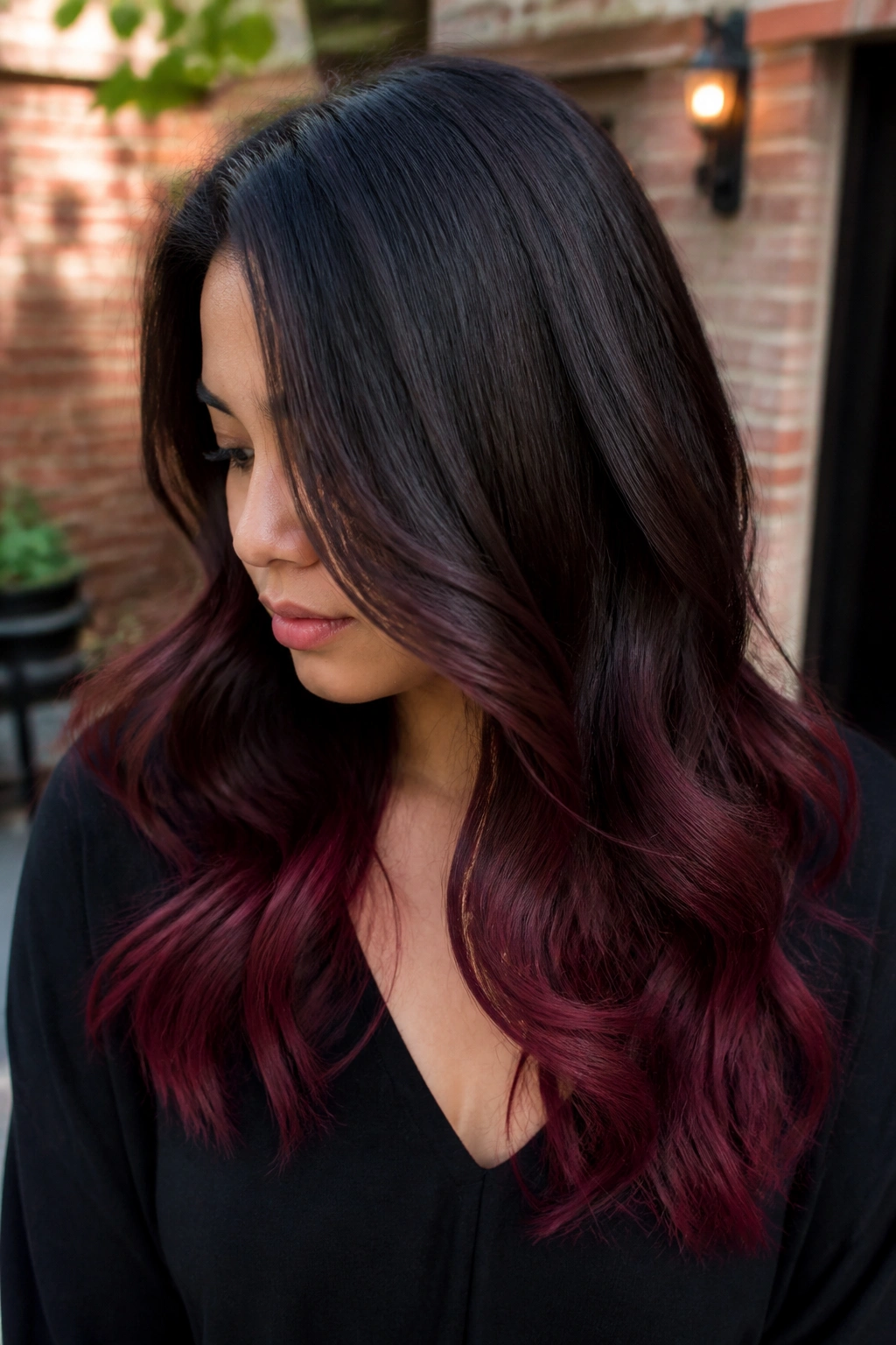 Close-up of a real person showing burgundy ombré ends with dark roots