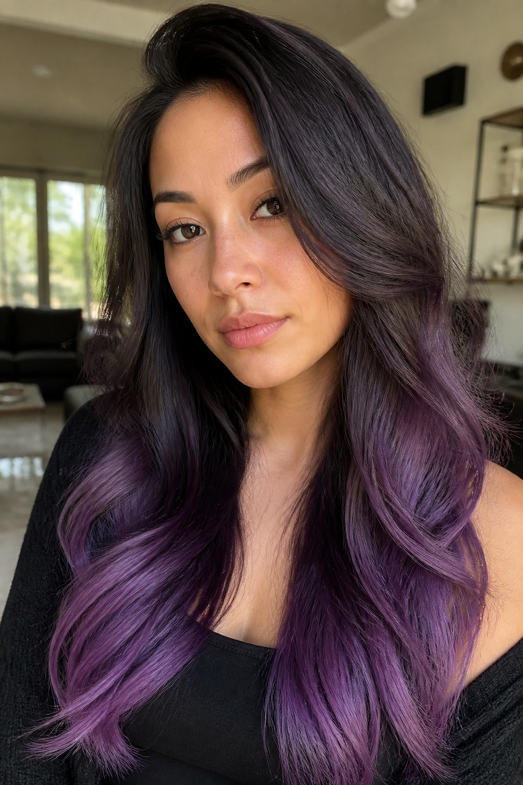 Close-up of a real woman's hair showing espresso roots fading to amethyst ends on long brunette hair.