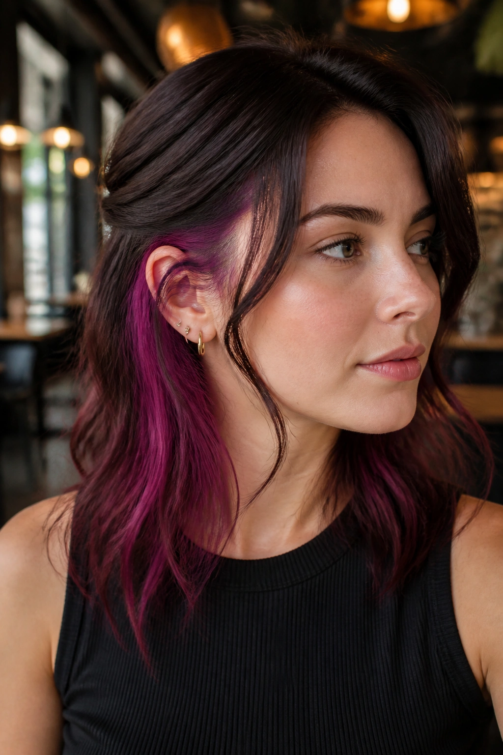 Portrait of a woman with orchid wine peekaboo underlayer in burgundy hair