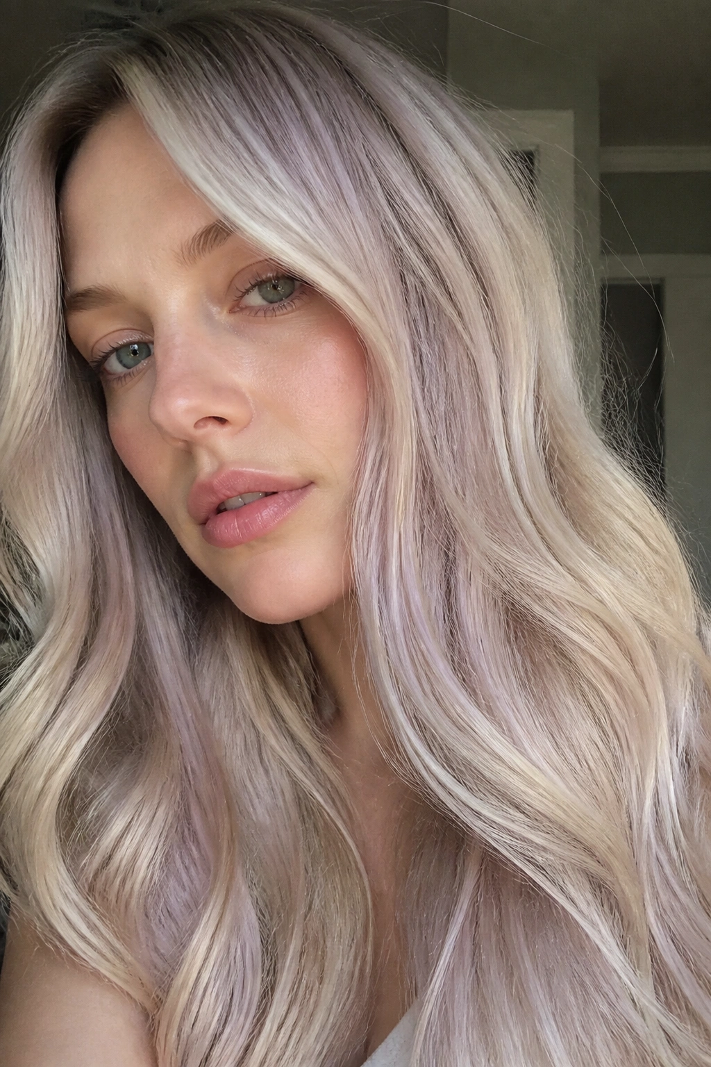 Close-up of a real person with pale sand hair and lilac gloss in neutral light