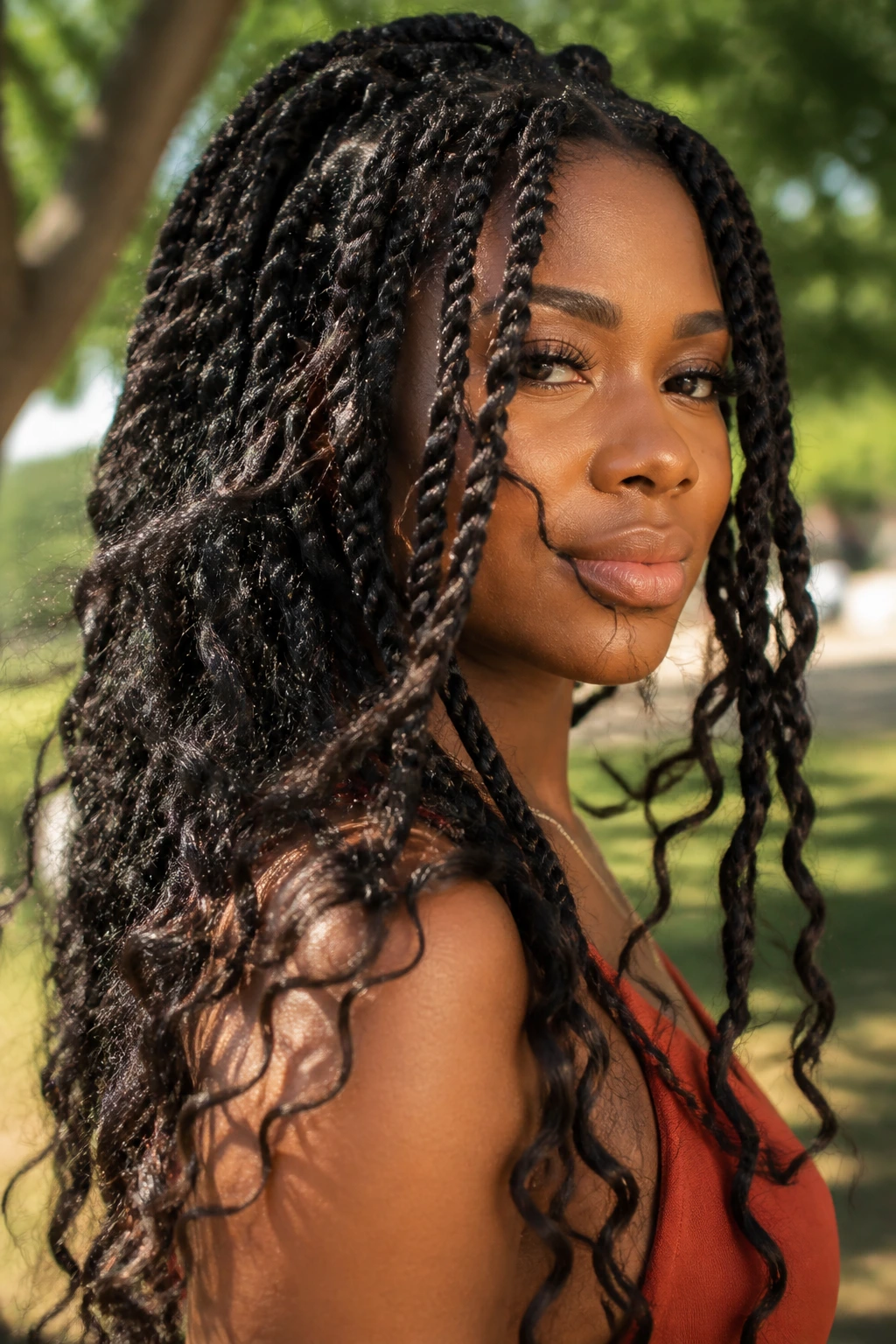 Portrait of a real woman with passion twists in a sunny outdoor setting