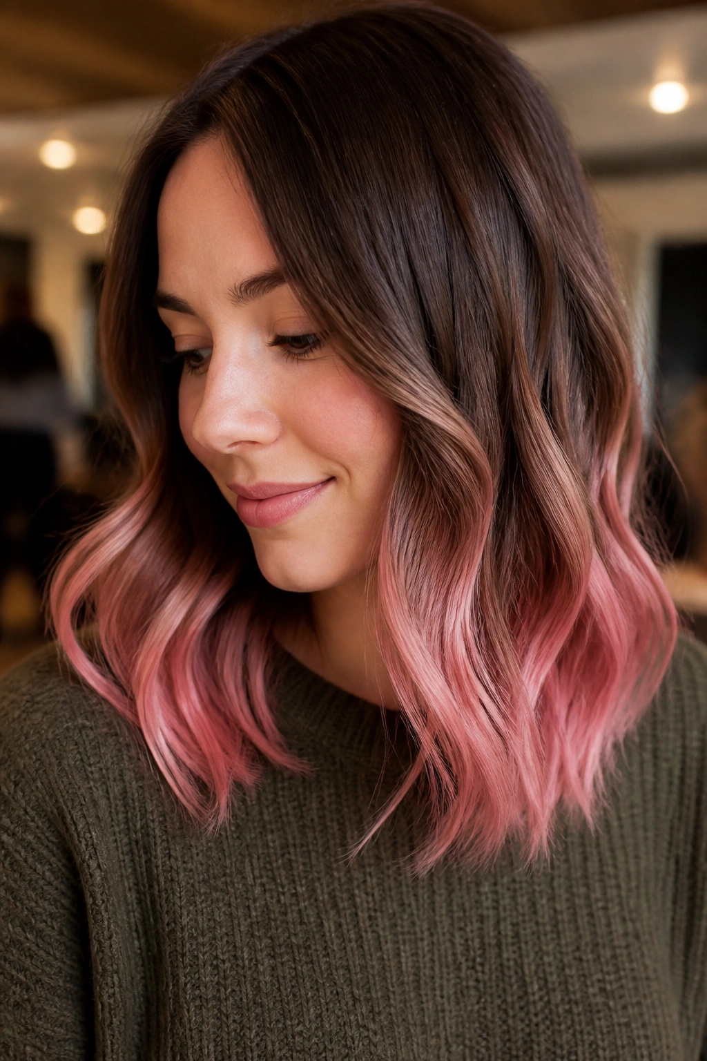 Close-up of chestnut hair with pastel pink ends on a real woman.