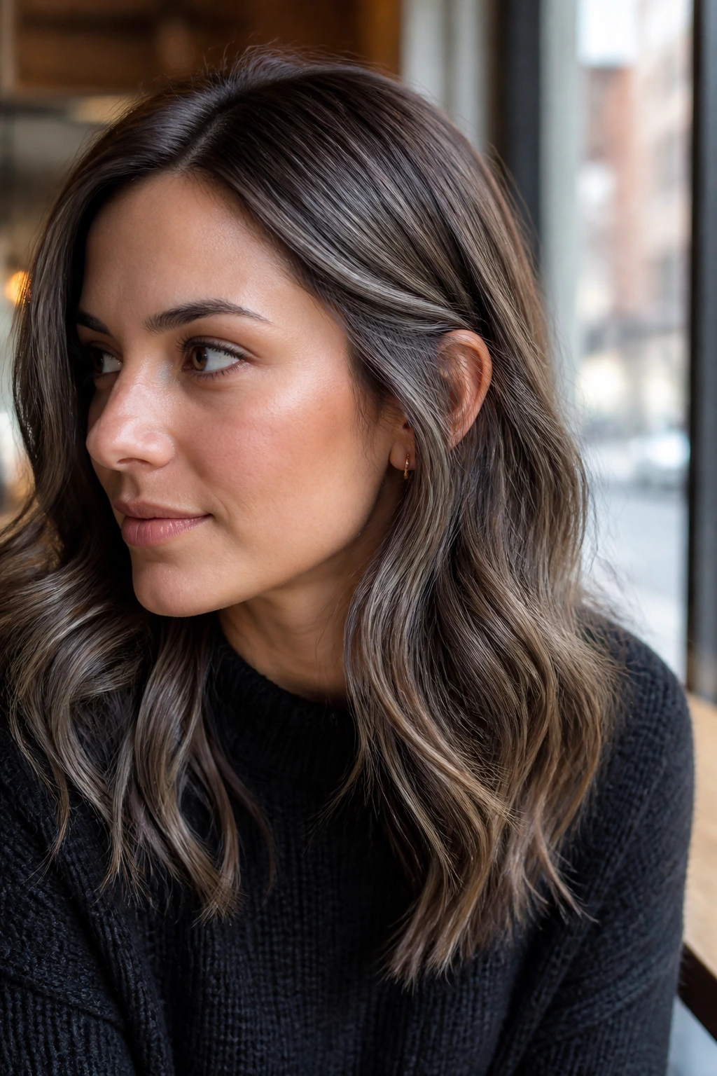 Real woman with mocha brown hair and pearl-gray babylights viewed in soft natural light
