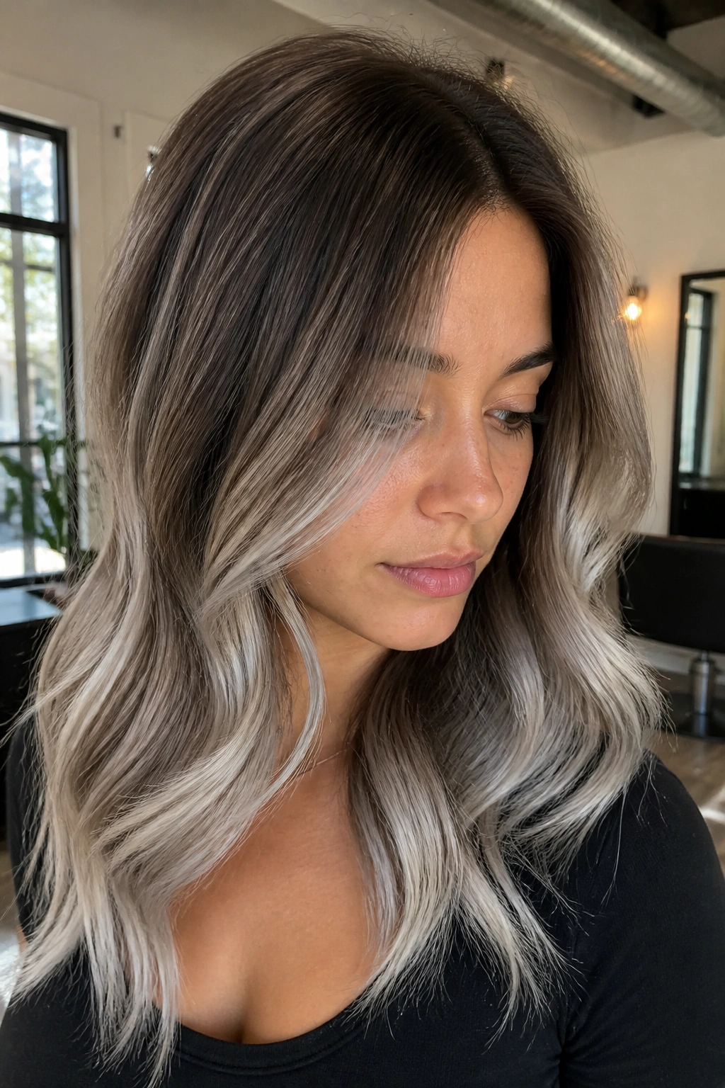 Close-up of medium brown hair with pearl silver balayage and soft root melt on a real person