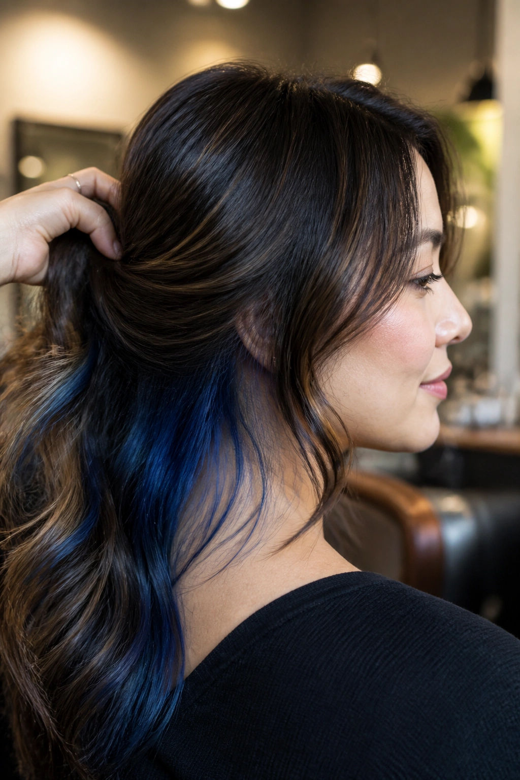 Close-up of a real woman showing hidden blue underlayers at the nape peeking through layered hair