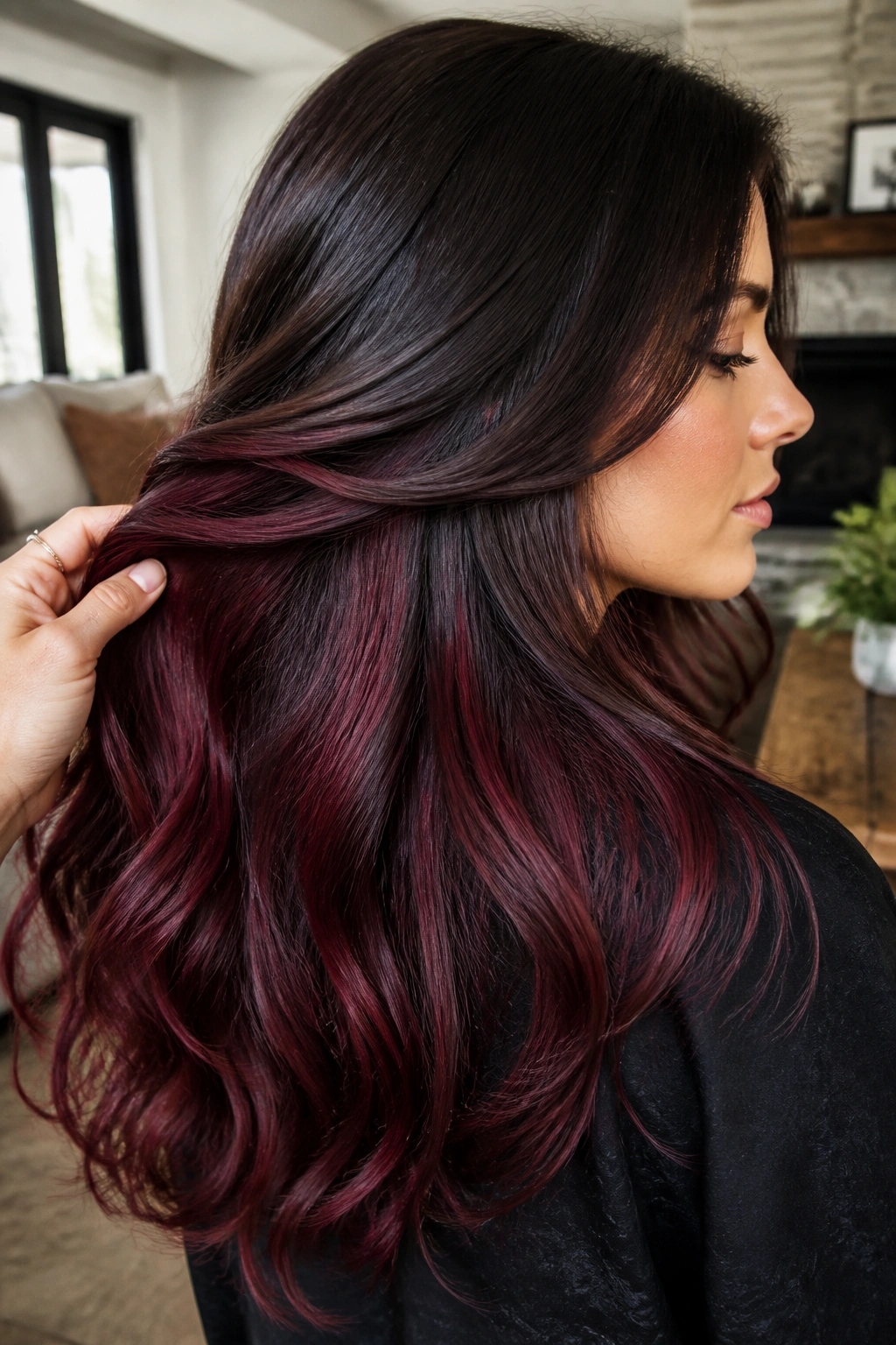 Side profile of a woman showing burgundy peekaboo underlayers