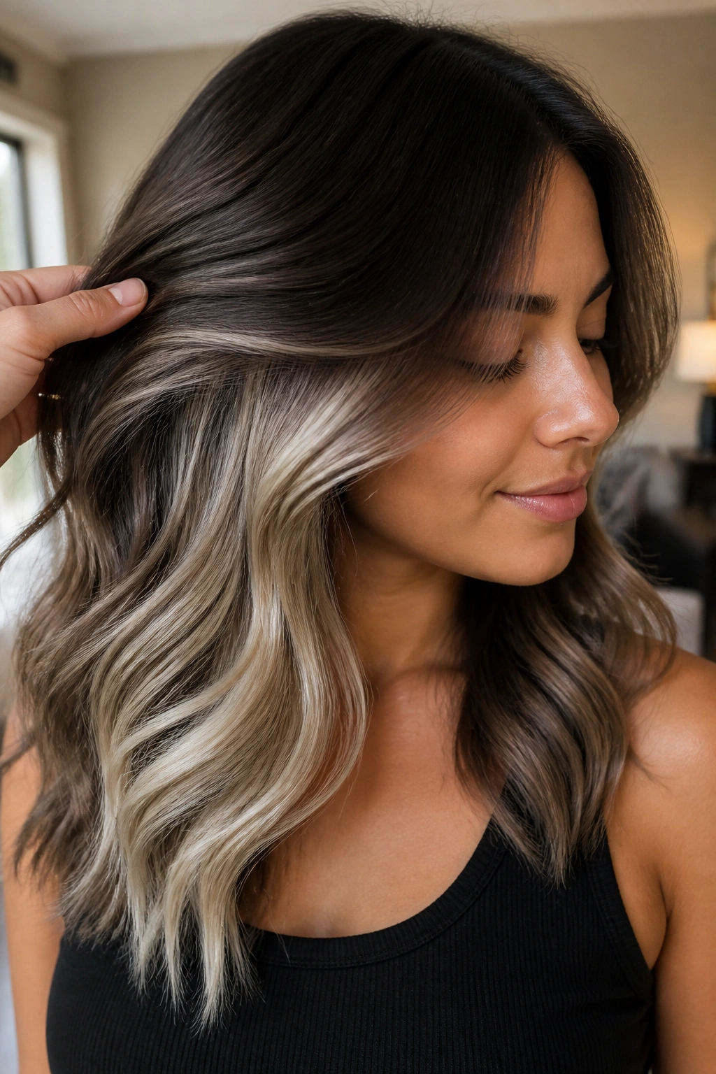 Close-up of brunette with platinum peekaboo highlights under the top layer