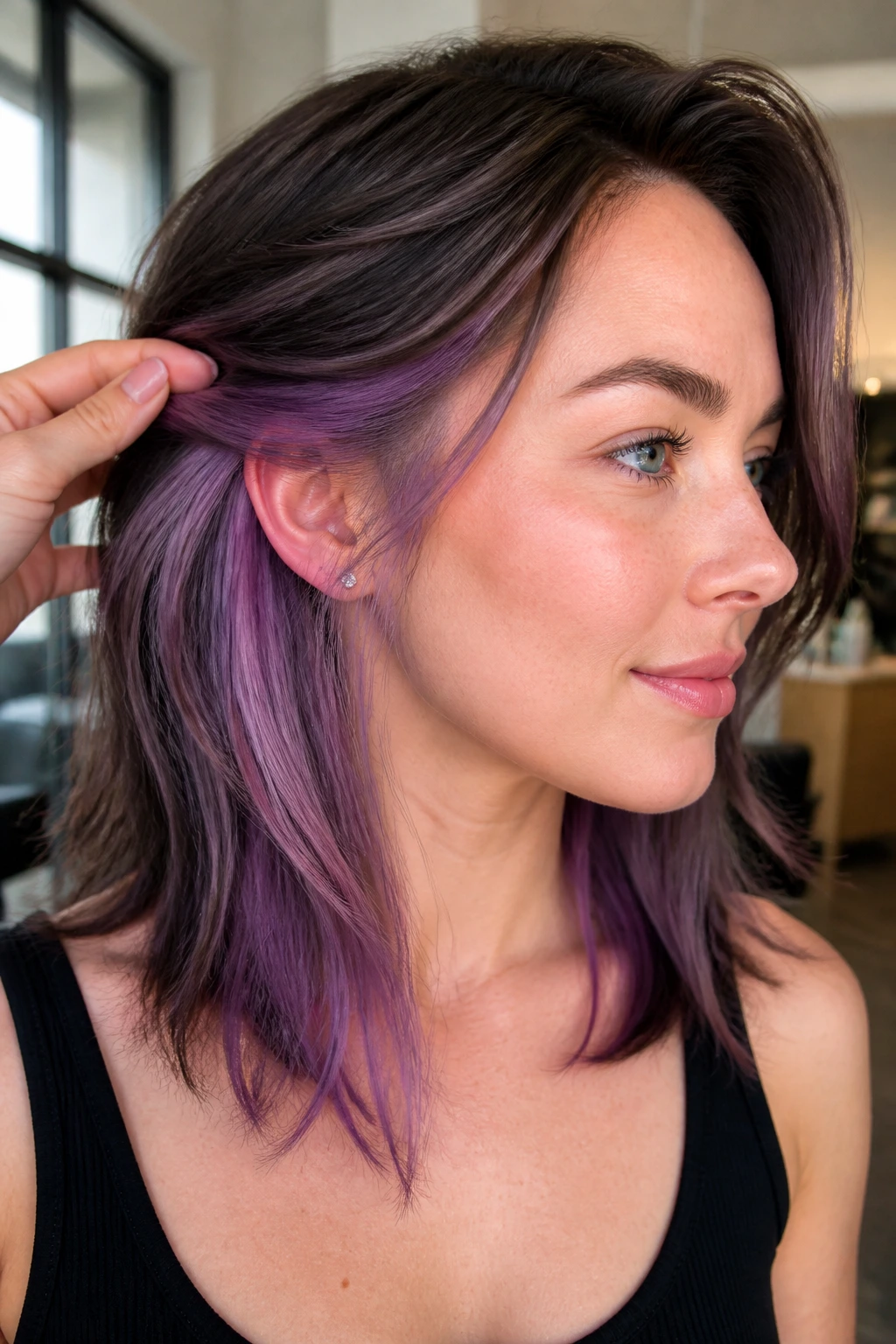 Close-up portrait of a woman with peekaboo lilac panels tucked behind the ear