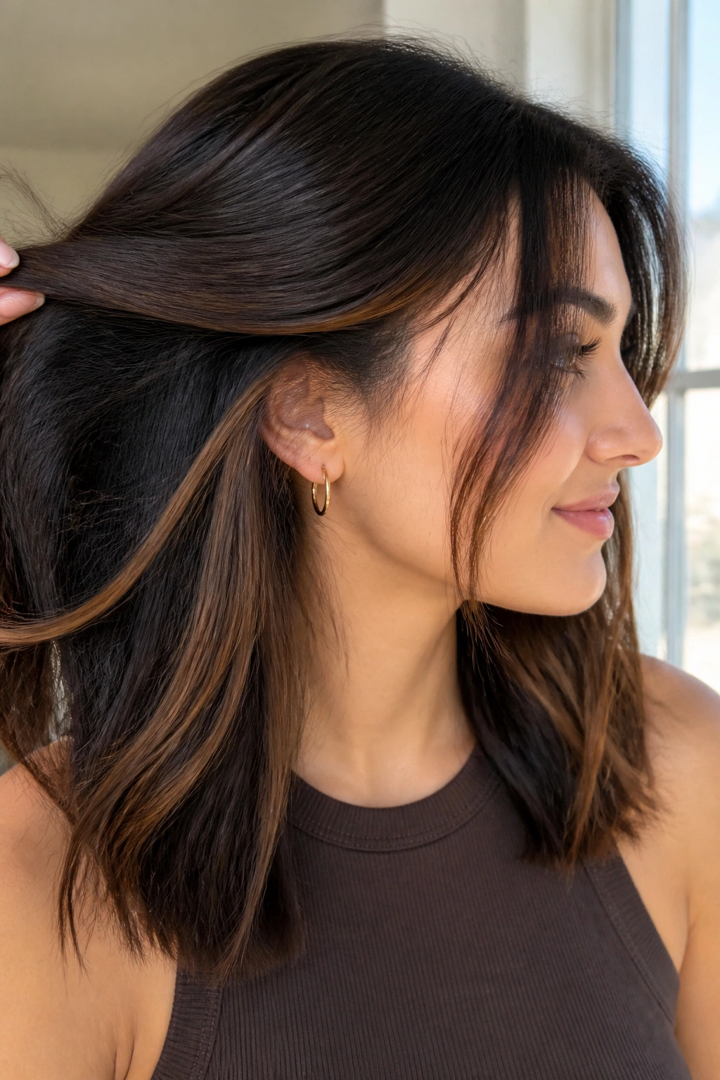 Portrait of a person showing subtle peekaboo panels under the top hair layer.