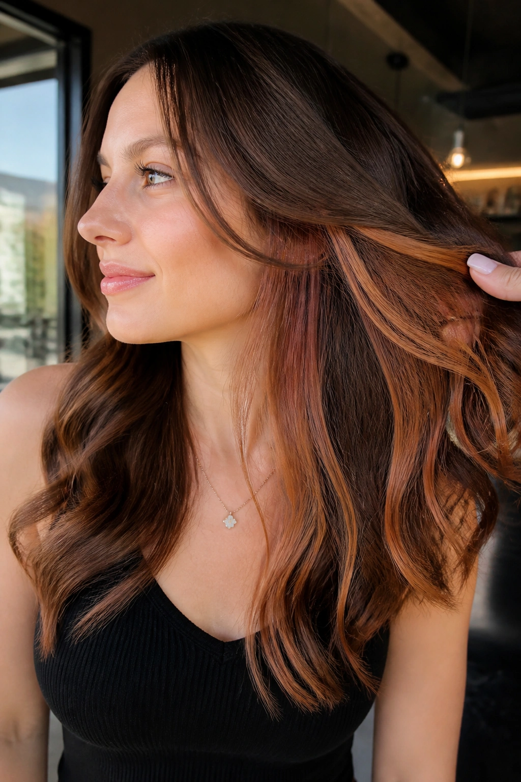 Close-up of a woman showing peekaboo strawberry panels under brown hair