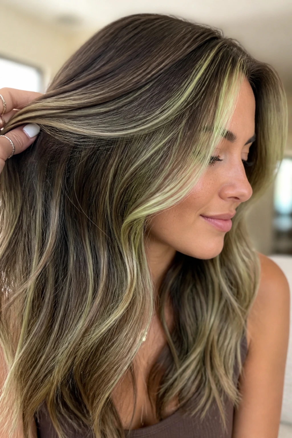 Close-up of brunette with pale pistachio babylights on the hair
