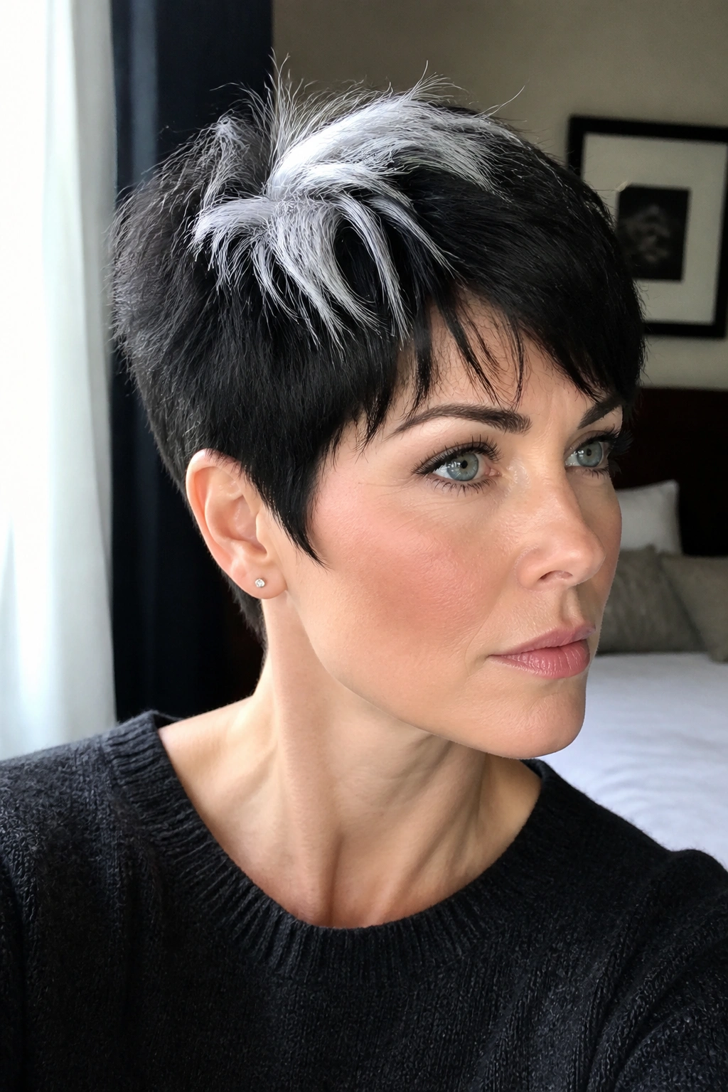 Close-up of a real woman with black pixie and white crown highlight on cool skin.