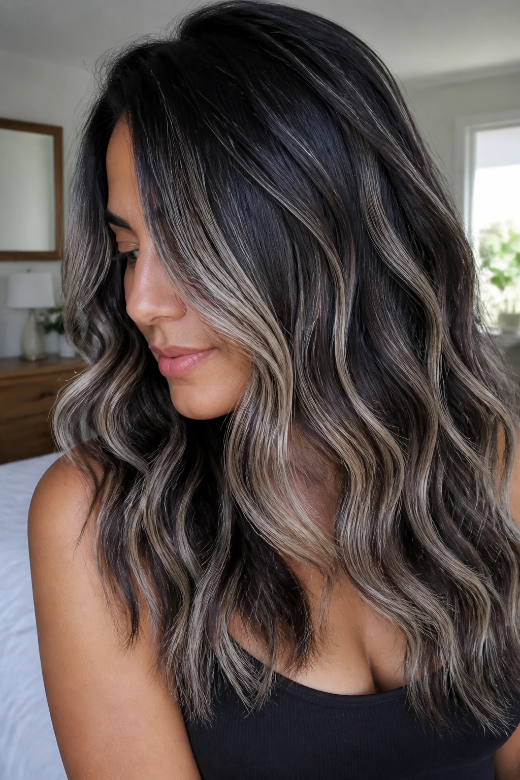 Real woman with platinum ribbons in dark wavy hair under window light