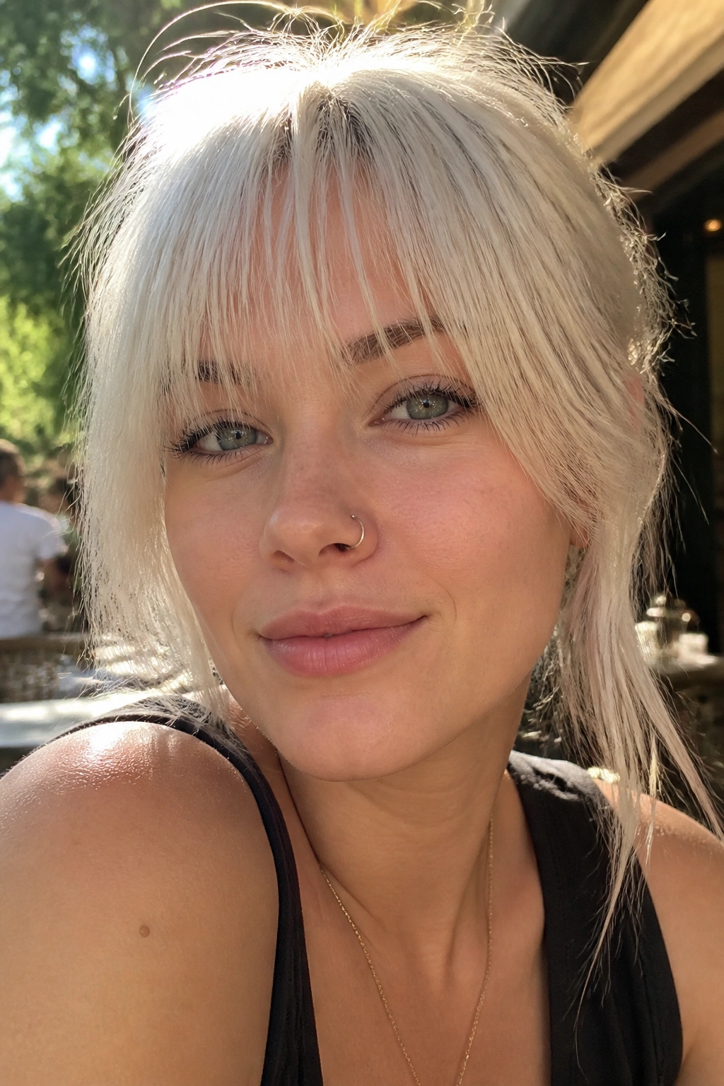 Close-up portrait of a real woman with wispy platinum bangs and airy ends.