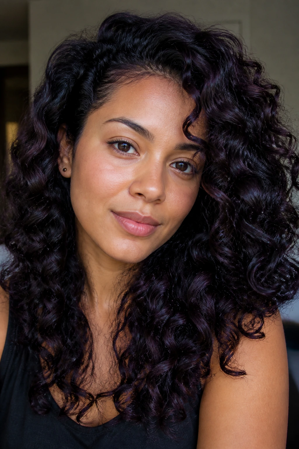 Close-up portrait of a real woman with plum-black hair and cool purple undertones.