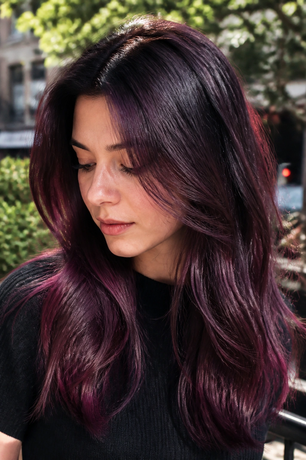 Close-up portrait of a real person with plum-black root melt hair gradient
