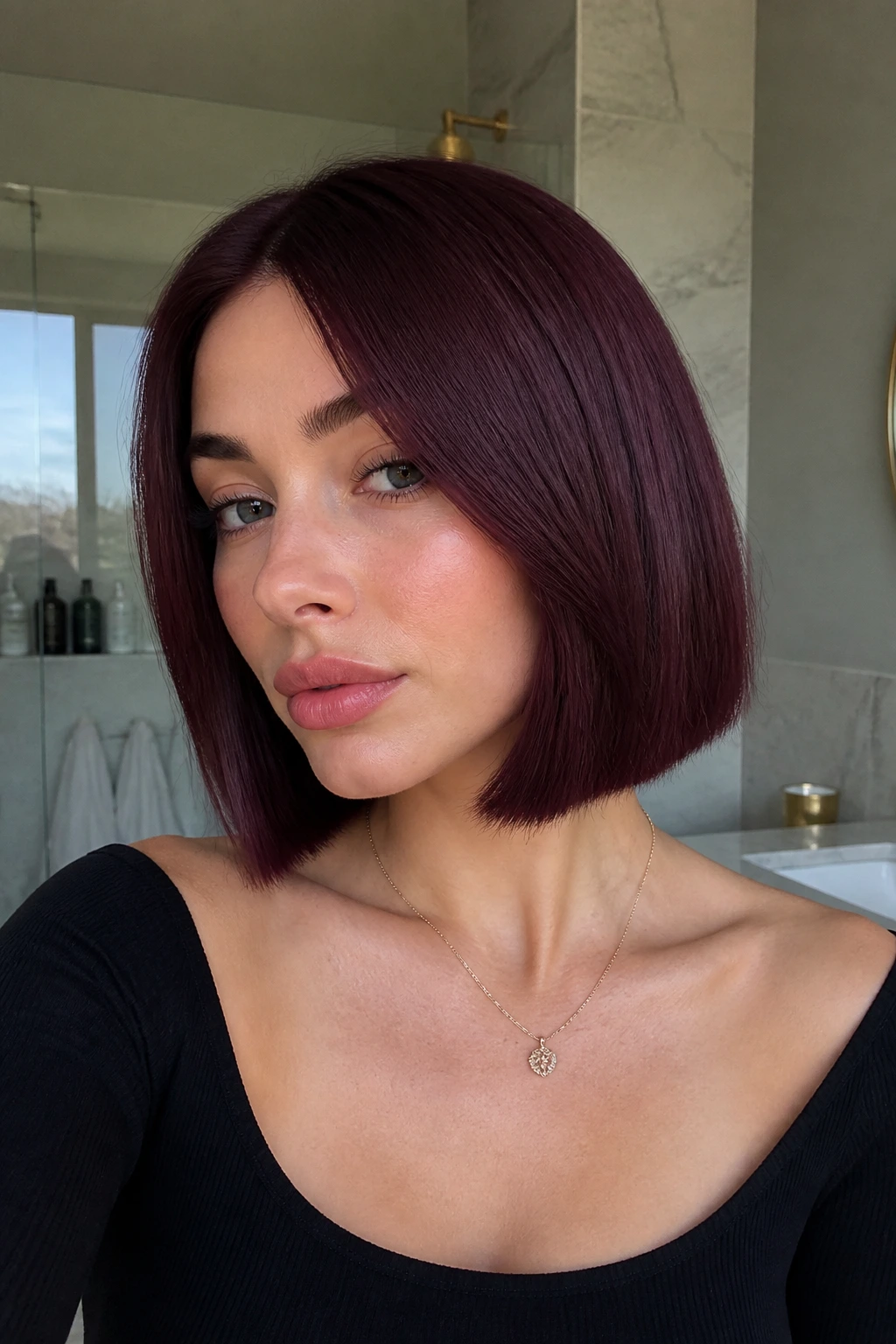 Close-up of a person with plum burgundy blunt bob in natural light