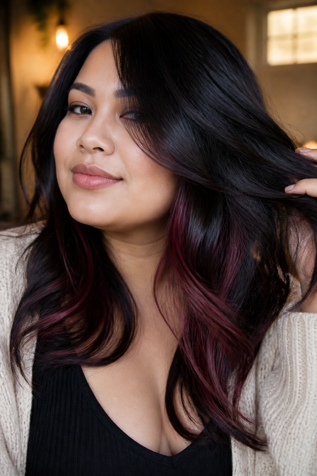 Close-up of jet-black hair with plum-red lowlights visible as it moves