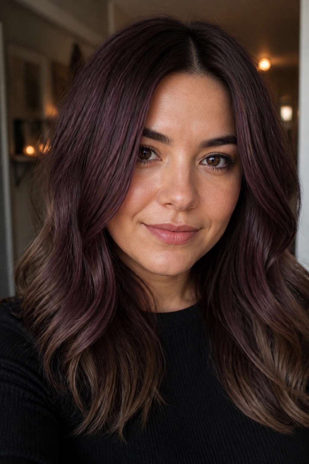 Portrait of a person with plum-tinted brown hair and neutral ends in warm light.