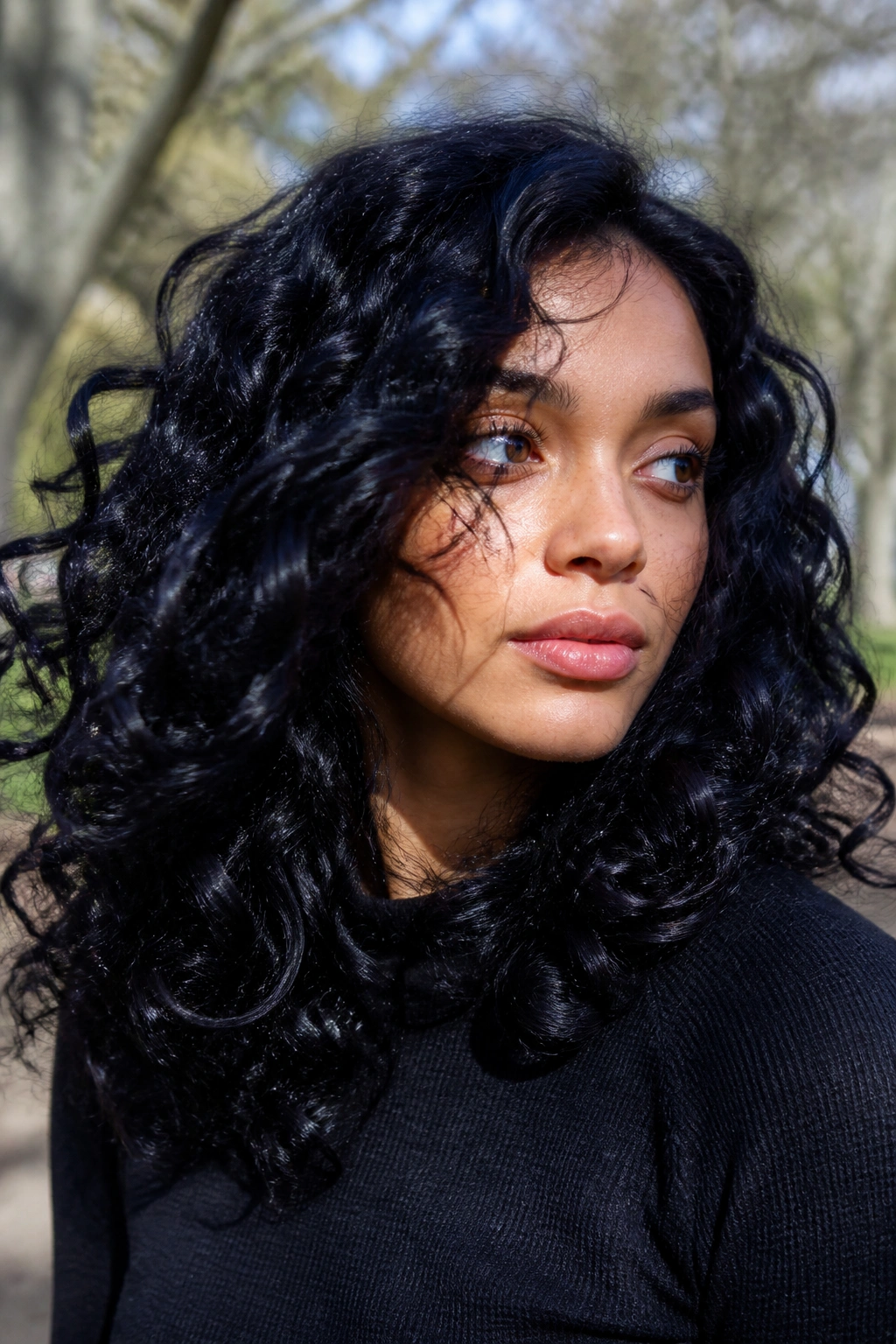 Close-up of real person with raven-black curls showing blue-violet undertones